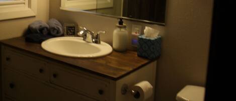 Ein Badezimmer mit Waschbecken, Spiegel und Toilette.