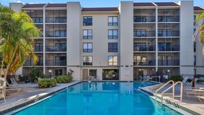Un hôtel doté d’une piscine, de plusieurs balcons et offrant une vue sur un ciel dégagé.