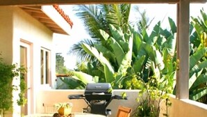 A covered patio with a table and chairs, a grill, and potted plants. - Charming Casita in Sleepy Beach Community (Encinitas)