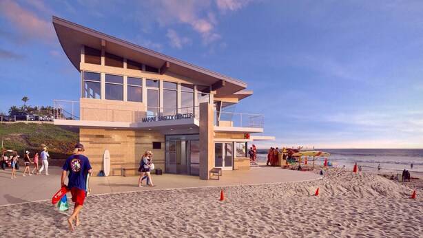 A modern lifeguard tower with a flat roof and large windows, located on a beach with people walking and beachgoers in the background. - Charming Casita in Sleepy Beach Community (Encinitas)