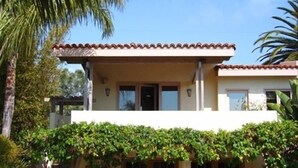 A two-story house with a tiled roof, a covered patio, and a garage. - Charming Casita in Sleepy Beach Community (Encinitas)