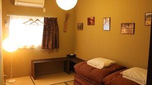 A room with a bed, bedside table, and a hanging light fixture. - Bar & Hostel MONDO - Hostel (Osaka)