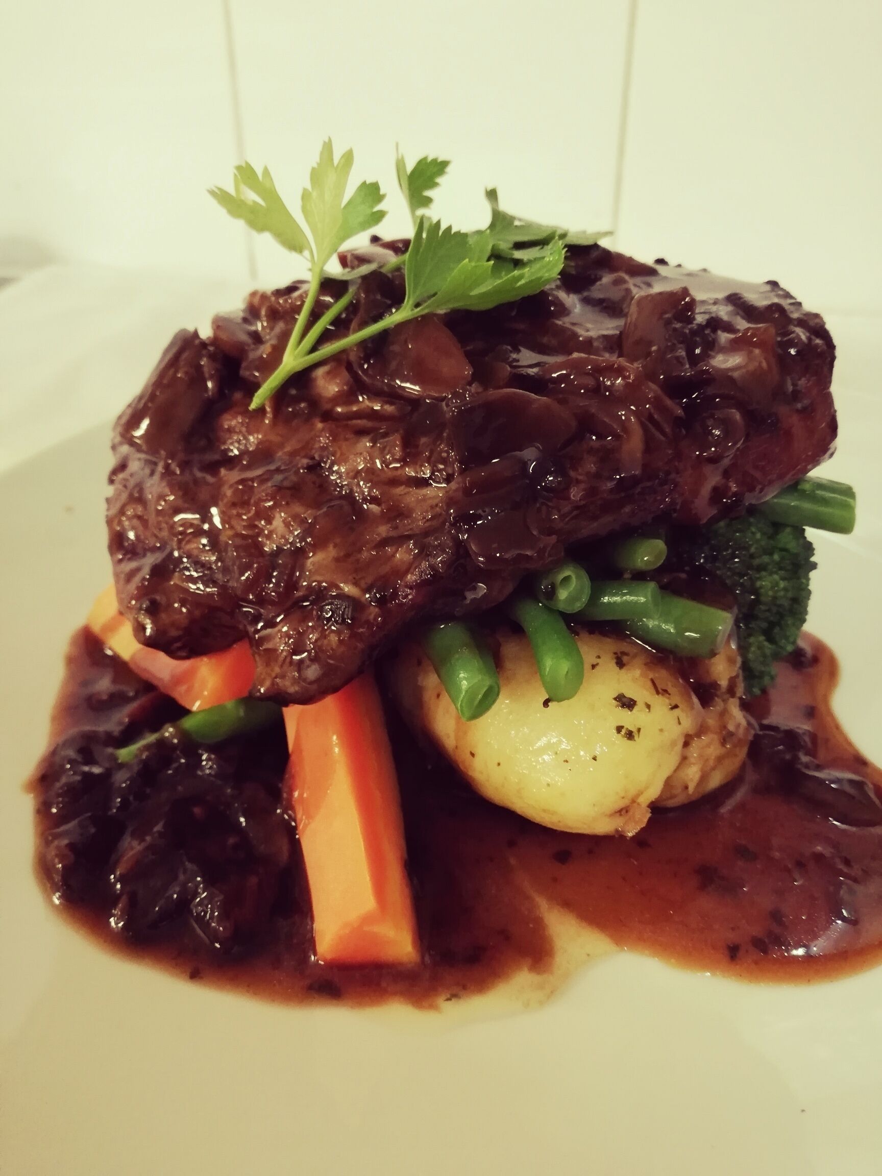 Un piatto di carne con verdure e guarnizione.