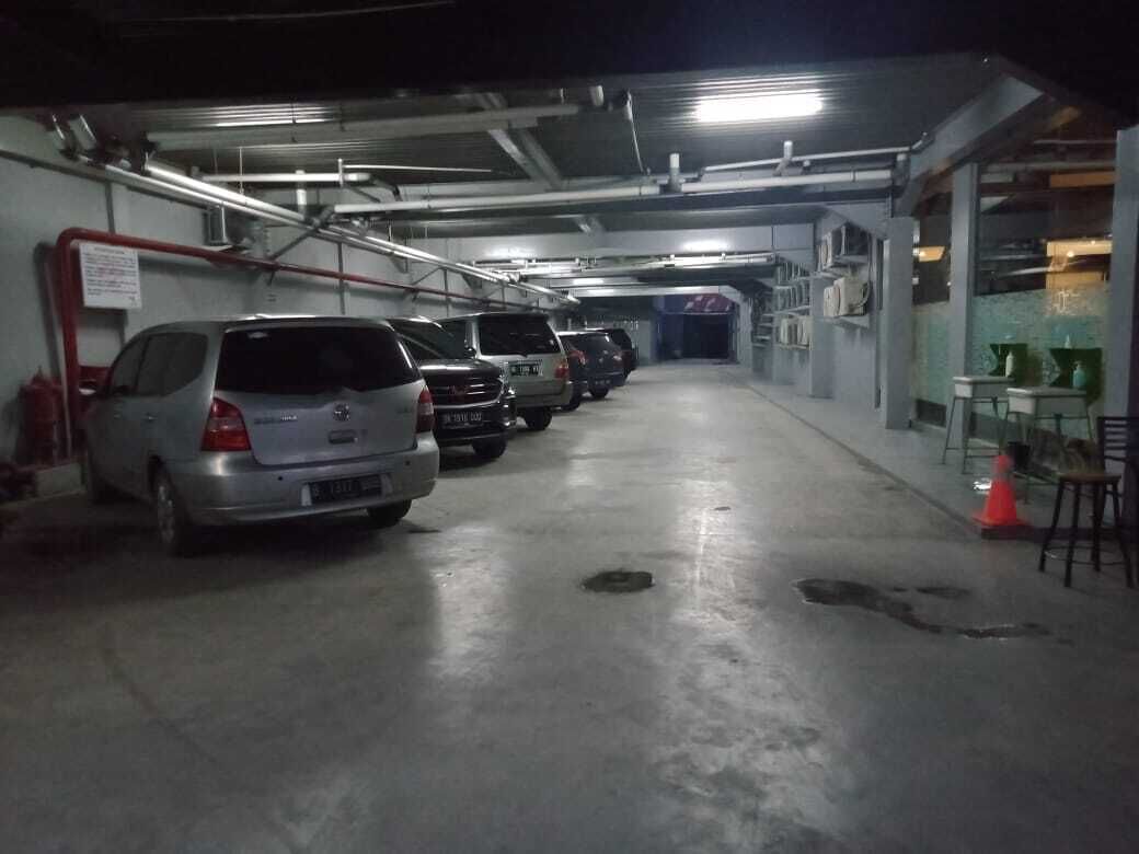 A parking garage with several cars parked in rows.