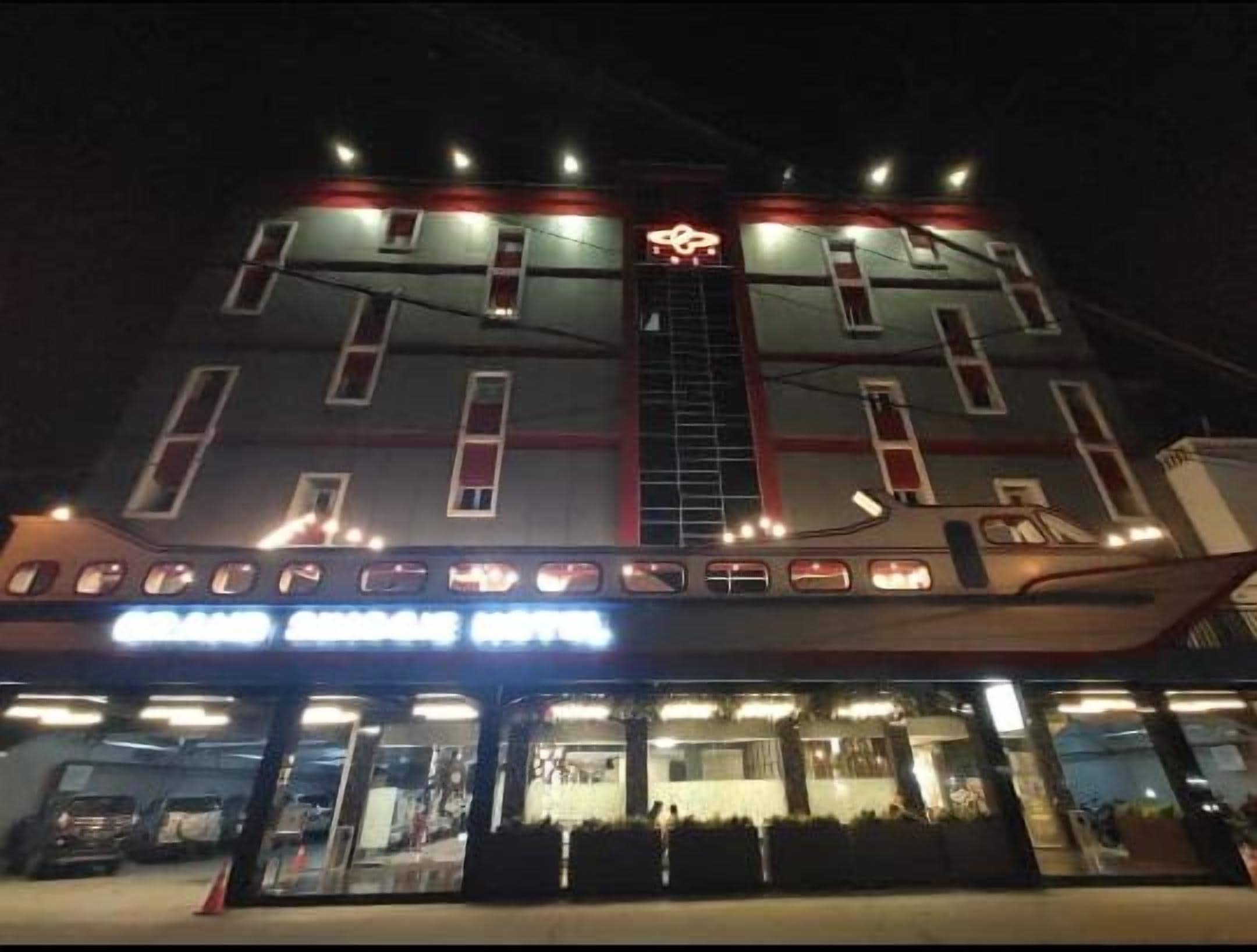 A multi-story hotel with a prominent entrance and a visible staircase leading to the upper floors.