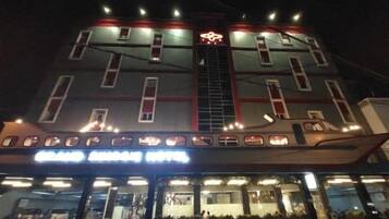A multi-story hotel with a prominent entrance and a visible staircase leading to the upper floors.