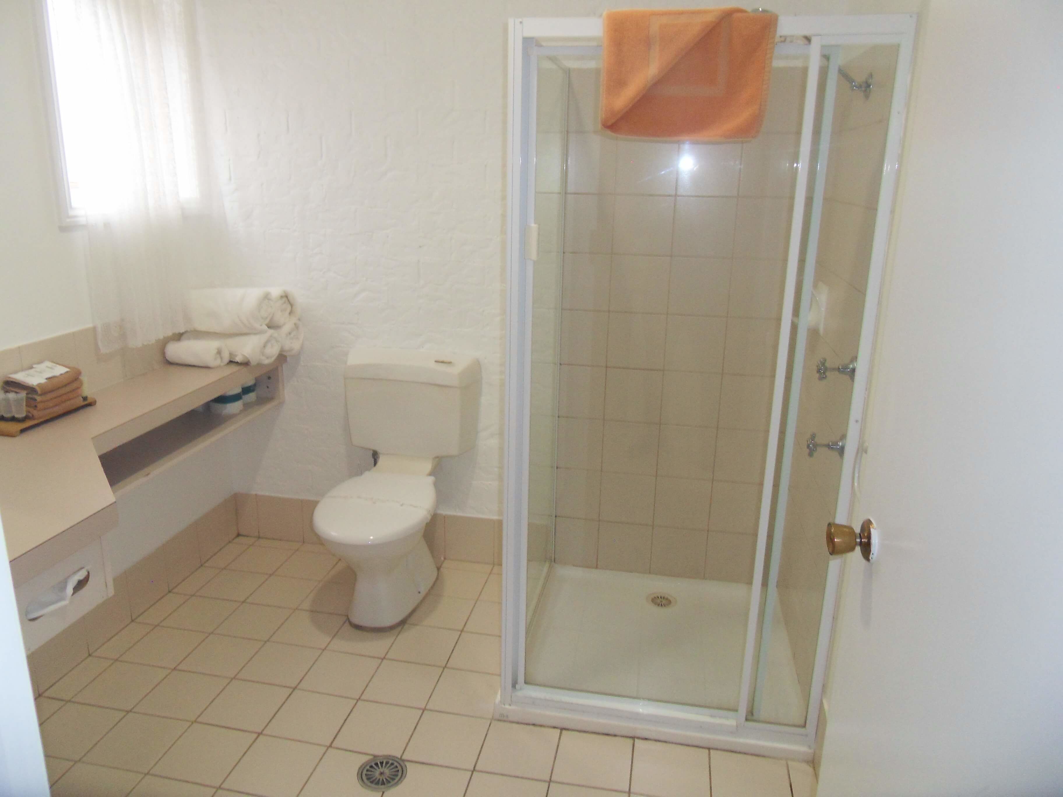 A bathroom with a toilet, sink, and shower.