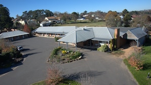 A large building with multiple covered parking areas and a central courtyard. - Swaggers Motor Inn (Yass)