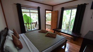 A hotel room with a bed, a bench, and a view of the outdoors. - Anawin Bungalows (Krabi)