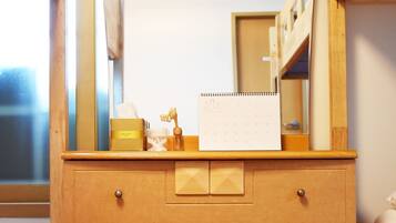 A wooden dresser with a mirror, a small stool, and a calendar.
