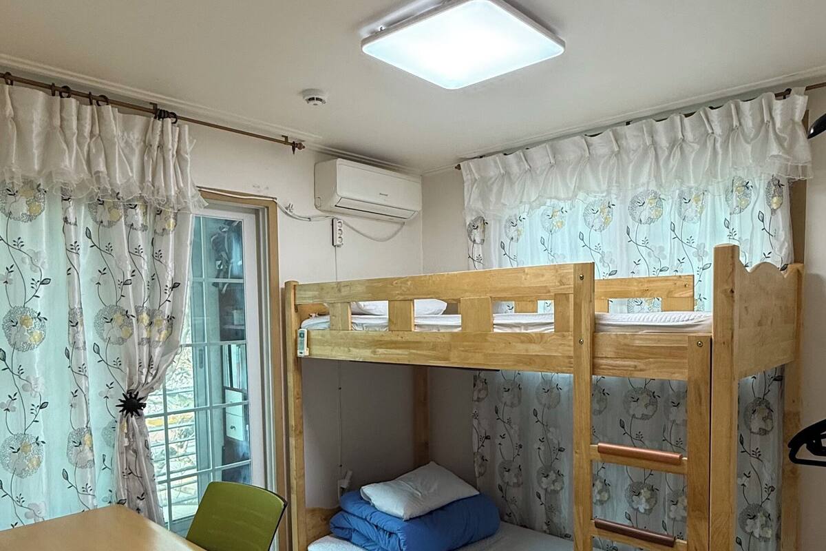 Une chambre avec un lit superposé, un bureau et une chaise.