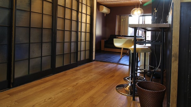 A room with wooden flooring, sliding doors, and a dining area with a table and chairs. - JQ Villa Kyoto Maiko Han-Inn (Kyoto)
