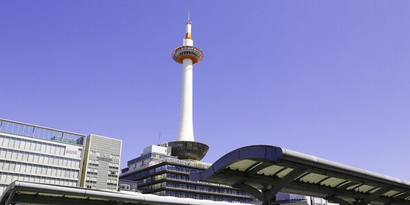 A modern building with a prominent tower, a covered walkway, and a sign indicating it is a hotel. - Kyomai Inn (Kyoto)