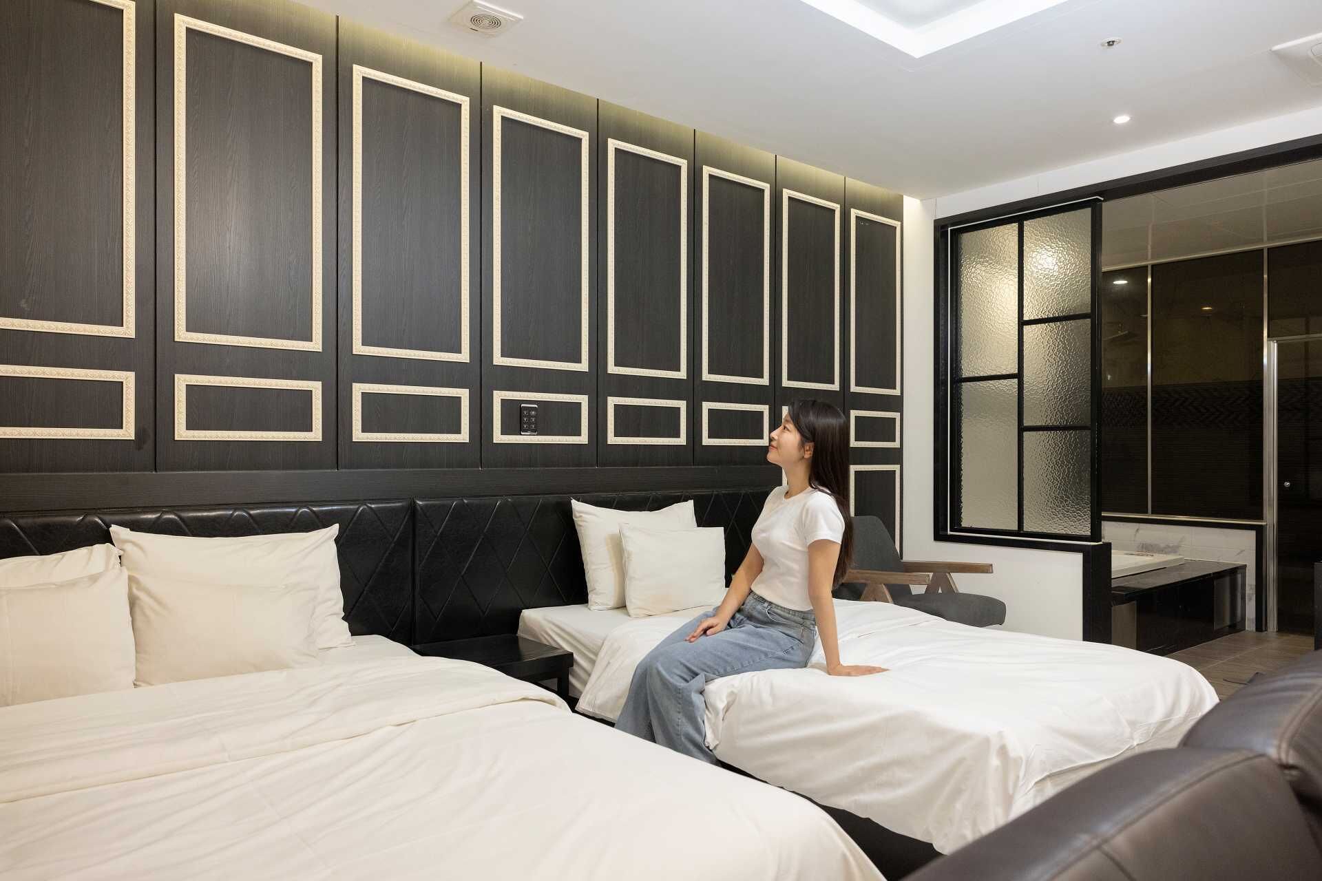 Une chambre d’hôtel avec deux lits, une grande fenêtre et un design moderne.