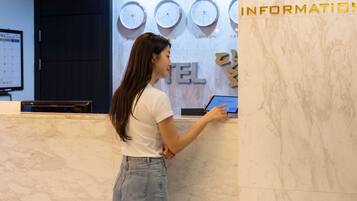 A reception desk with a digital screen displaying 'dodo point' and clocks showing different times.