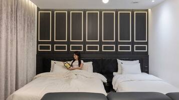 Un dormitorio moderno con una cama grande, dos camas más pequeñas y un diseño de cabecera único.