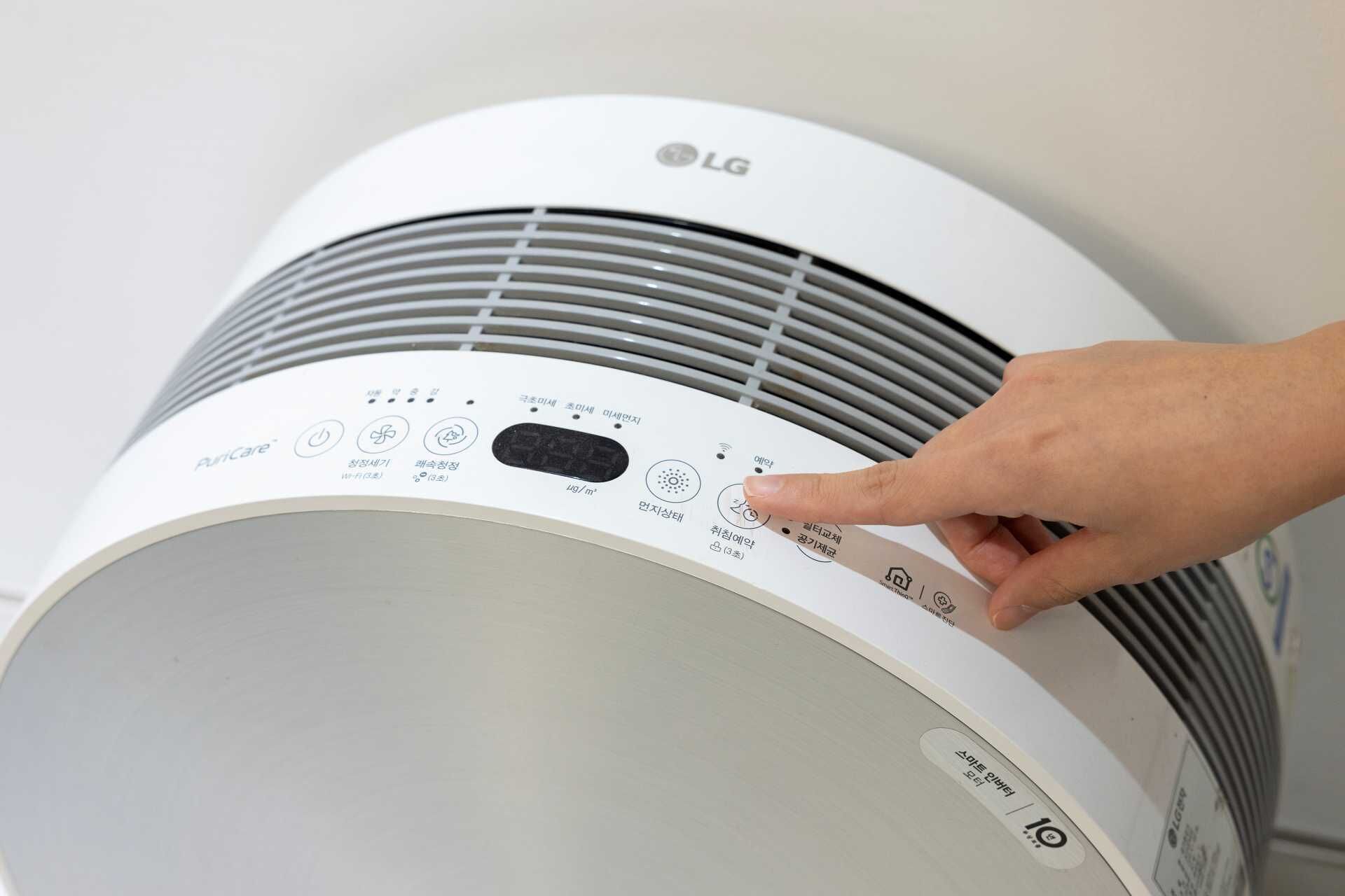 A white LG air conditioner with a control panel featuring multiple buttons and a digital display.