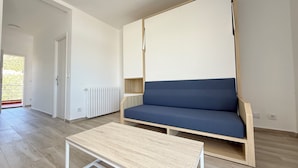 A modern living room with a sofa, a coffee table, and a radiator.