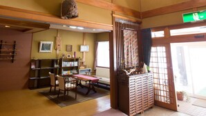 Et traditionelt japansk rum med tatamimåtter, et lavt bord og en futon.