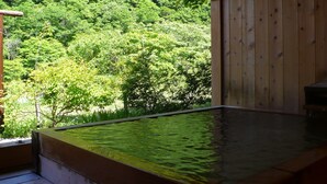 En træhytte med jacuzzi og udsigt til en frodig skov.