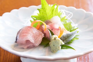 A white plate with sashimi and garnishes. - Houzansou Bekkan (Takayama)
