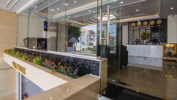 Un espace d’accueil doté d’un comptoir en marbre, de cloisons en verre et d’une enseigne de bienvenue.