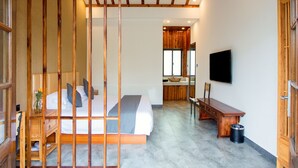 A bedroom with a bed, bedside table, wooden headboard, and a TV mounted on the wall. - Shanghai Linxi Hotel-Free shuttle bus to Pudong Airport and Disneyland (Shanghai)