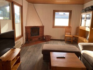 A cozy living room with a fireplace, a television, and a comfortable seating area.