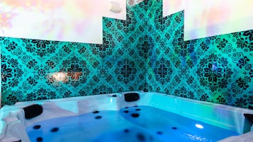 Un bain à remous avec un mur à motifs bleus et noirs en arrière-plan.