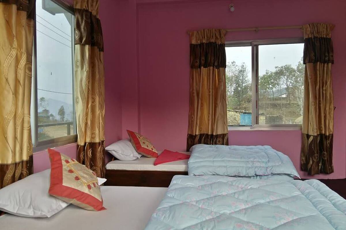 A room with two beds, a window with curtains, and a view of the outside.