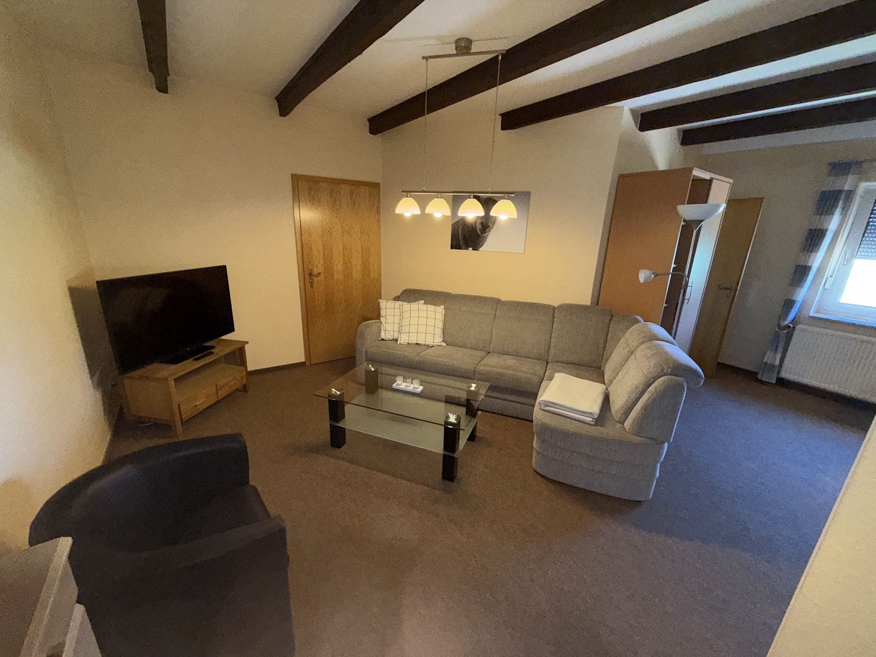 A living room with a television, sofa, and coffee table.