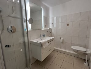 Een haardroger, handdoeken, zeep, toiletpapier