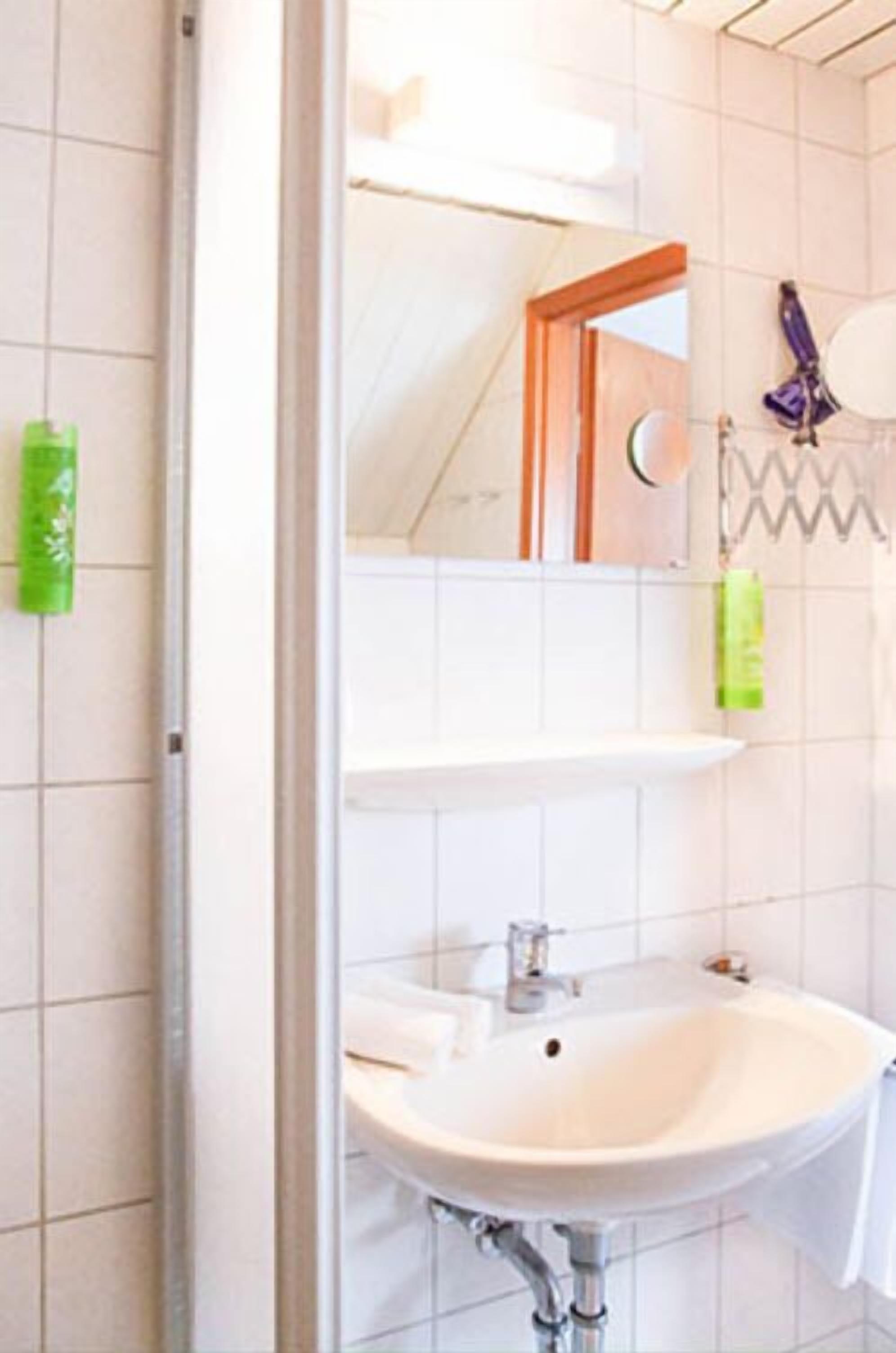 A bathroom with a white sink, a mirror, and a towel rack.