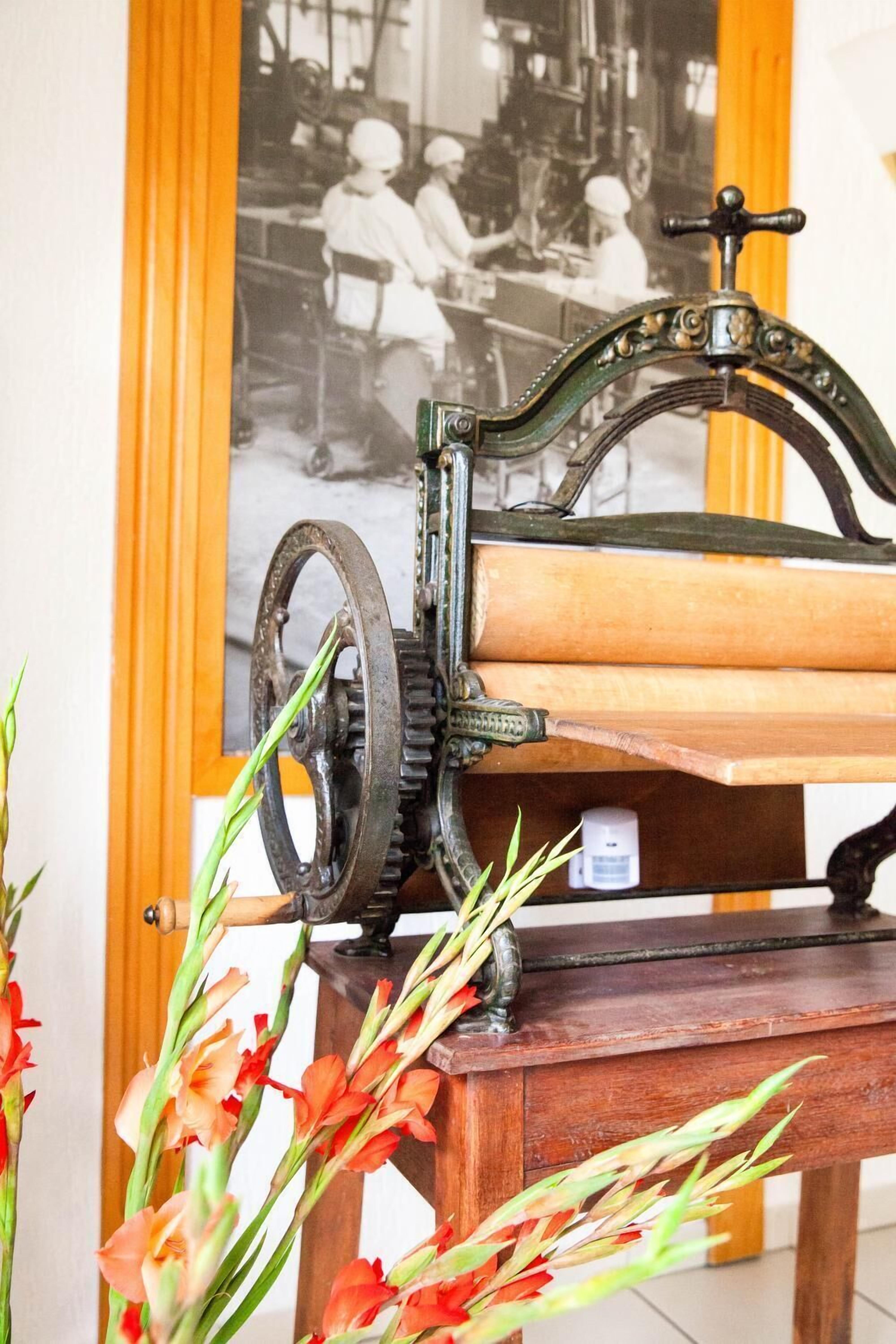 A vintage mechanical device with gears and a lever, placed on a wooden table.