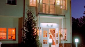 A two-story hotel with a balcony, a staircase leading to the entrance, and a sign indicating it is a hotel. - Craft Berry GmbH Hotel and Restaurant at the Milestone (Jerichow)