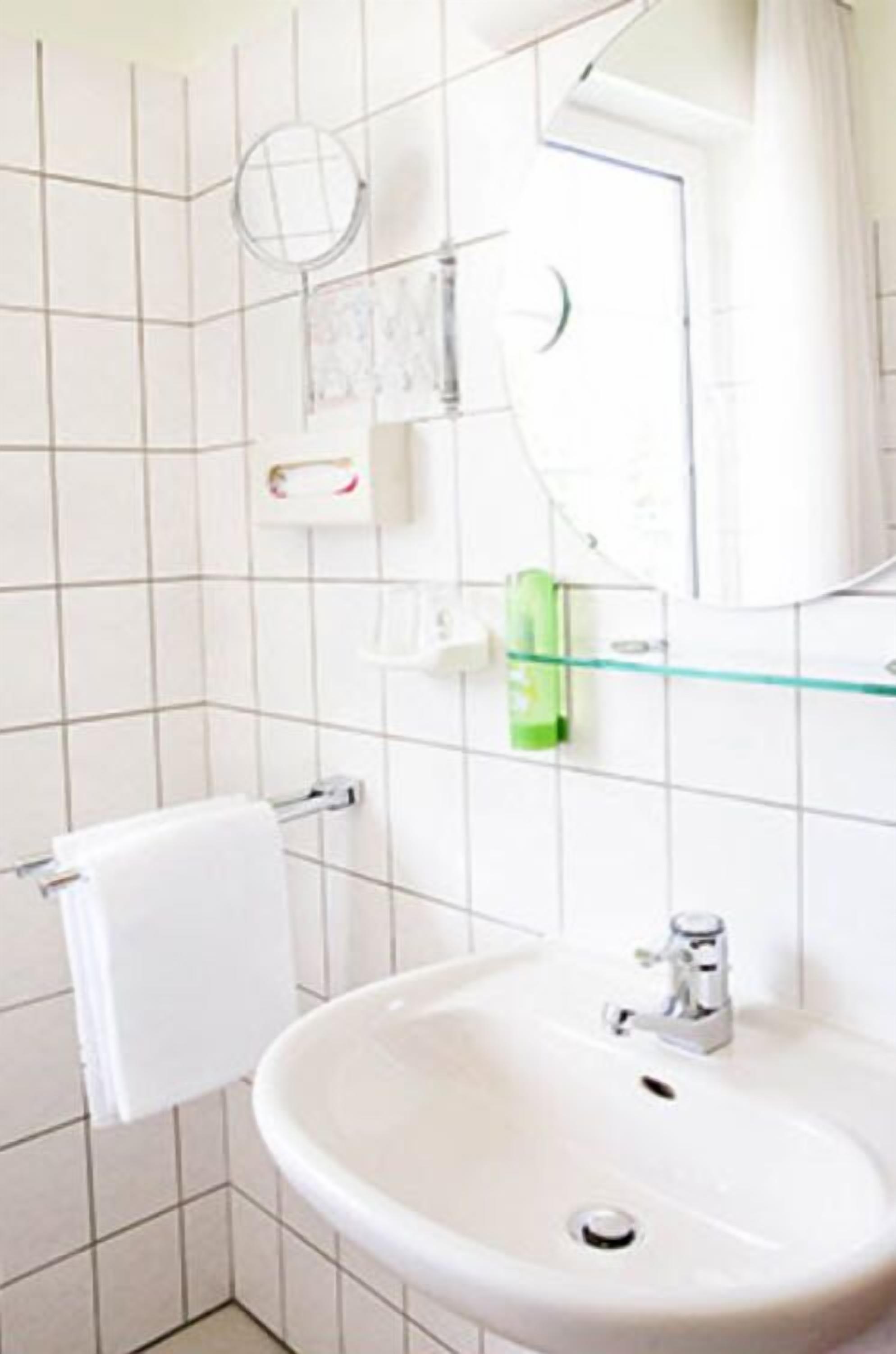 Ein Badezimmer mit Waschbecken, Spiegel und Handtuchhalter.