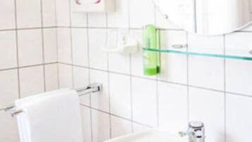 Ein Badezimmer mit Waschbecken, Spiegel und Handtuchhalter.