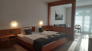 A hotel room with a large bed, bedside tables, a mirror, and a view of a balcony. - Craft Berry GmbH Hotel and Restaurant at the Milestone (Jerichow)