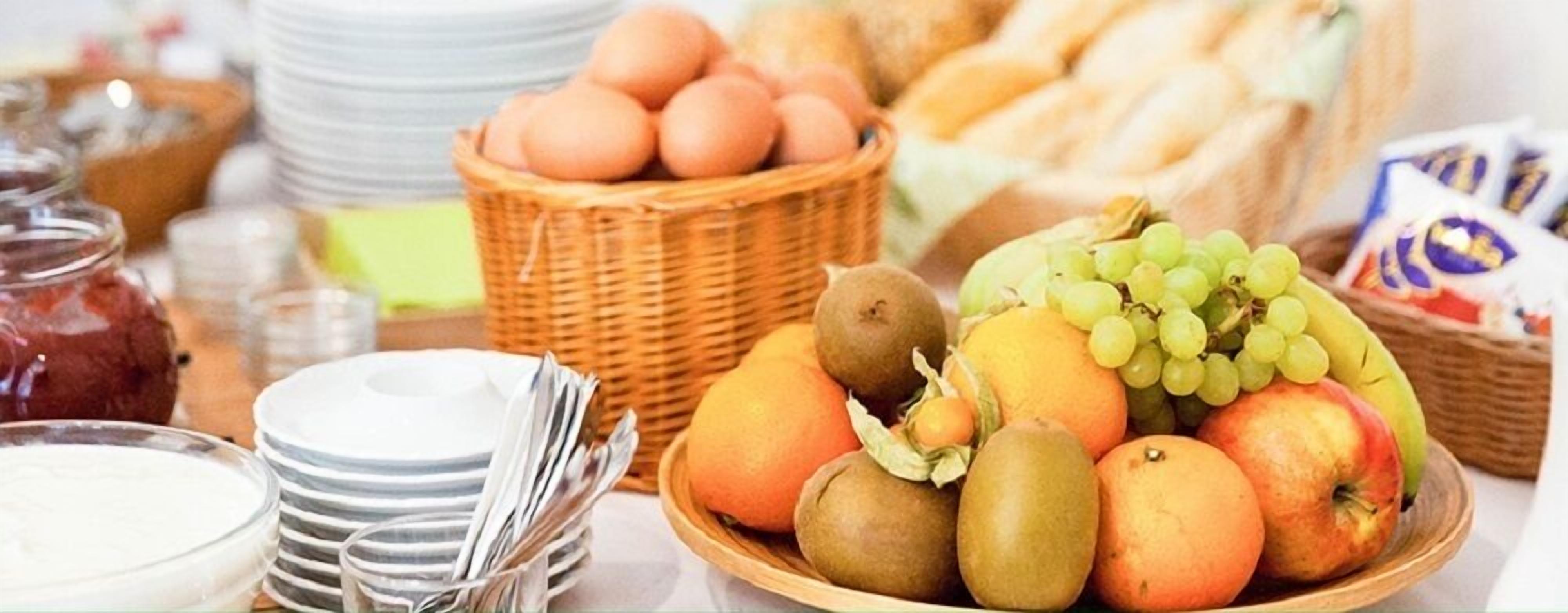 Un bufé de desayuno con frutas, huevos y pan.