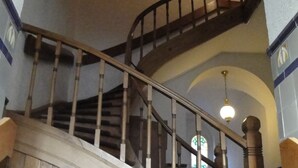 A wooden staircase with a curved railing leading to a landing.