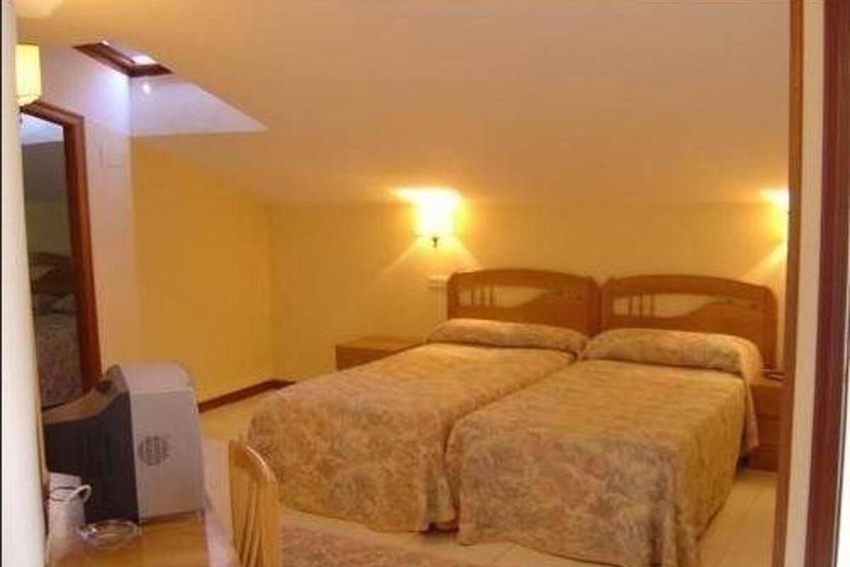 Un dormitorio con dos camas, un escritorio y una silla.