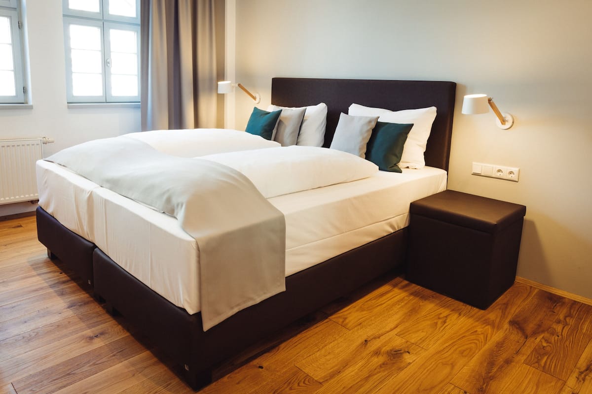 Ett modernt hotellrum med en stor säng, sängbord och utsikt över omgivningarna.