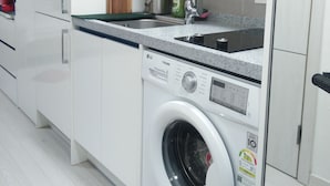 Een koelkast, een magnetron, een waterkoker, kookgerei, borden en bestek