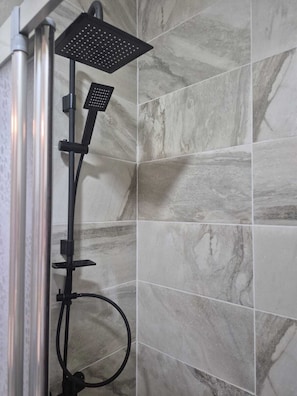A shower with a handheld head, a handheld showerhead, and a flexible hose. - Sanli Butik Hotel (Ayvalik)