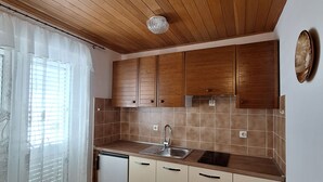 A kitchen with wooden cabinets, a sink, and a herringbone-patterned floor.