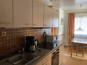 Keittiössä on pesuallas, liesi, mikroaaltouuni ja kahvinkeitin. Siellä on myös ruokapöytä ja tuolit.