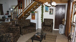 A living room with patterned sofas, a coffee table, a fan, and a staircase. - Sadadu (Nkomazi)