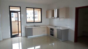 A modern kitchen with a large window, a dishwasher, and a sink. - Kileleshwa Lux Condo (Nairobi)