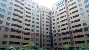 A multi-story residential building with a uniform facade, numerous windows, and a central courtyard with greenery. - Kileleshwa Lux Condo (Nairobi)