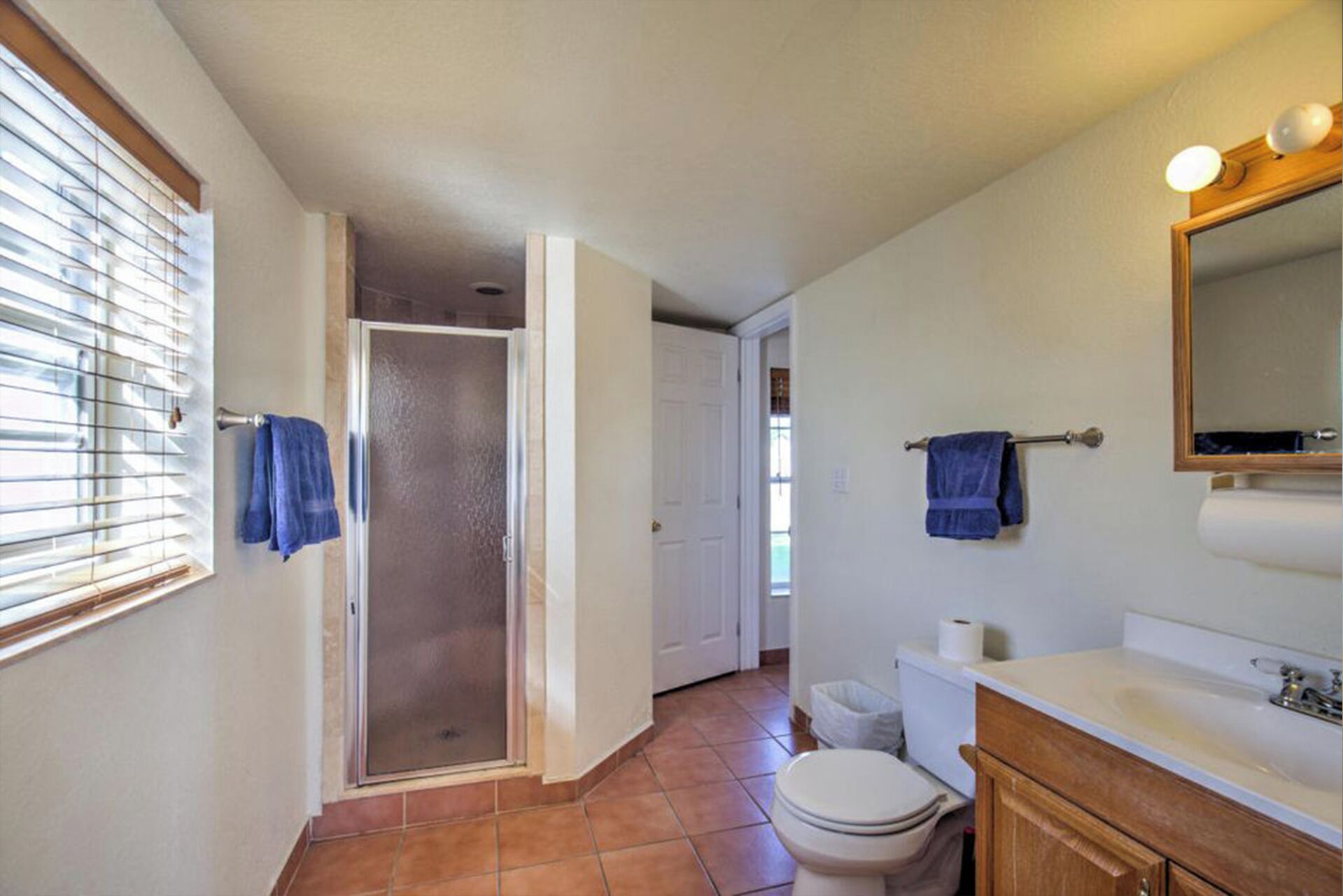 A bathroom with a toilet, sink, and shower.